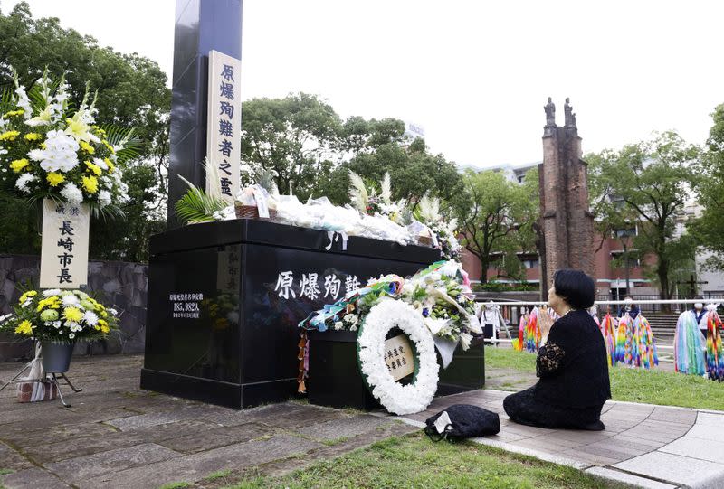 A woman prays for victims of the 1945 atomic bombing on a day commemorating the 75th anniversary of the bombing in Nagasaki, Japan