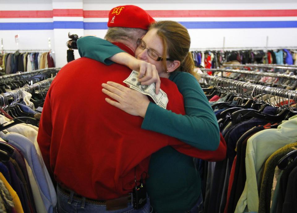 Janice Kennedy hugs Secret Santa after getting a $100 dollar bill from the wealthy philanthropist from Kansas City, Mo. while looking for clothes at the Salvation Army store in the boro of Staten Island, New York, N.Y., Thursday, Nov. 29, 2012. Secret Santa distributed $100 dollar bills to needy people at several locations in Elizabeth, N.J. and Staten Island. (AP Photo/Rich Schultz)