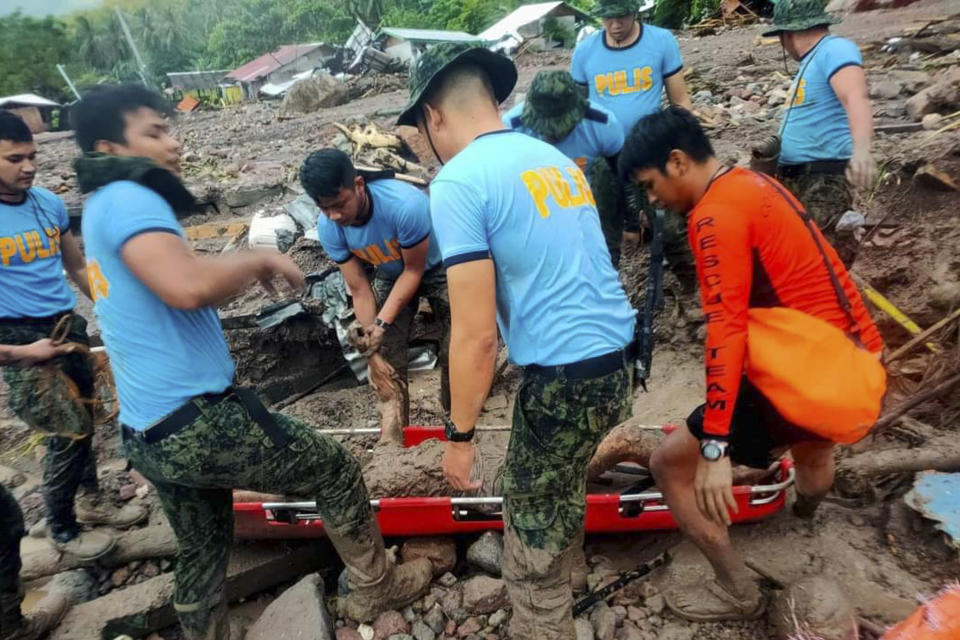 In this handout photo provided by the Philippine Coast Guard, rescuers retrieve bodies during the search and rescue operations in Barangay Kushong, Datu Odin Sinsuat, Maguindanao province, southern Philippines on Friday Oct. 28, 2022. Several people died while others were missing in flash floods and landslides set off by torrential rains from Tropical Storm Nalgae that swamped a southern Philippine province overnight and trapped some residents on their roofs, officials said Friday.(Philippine Coast Guard via AP)
