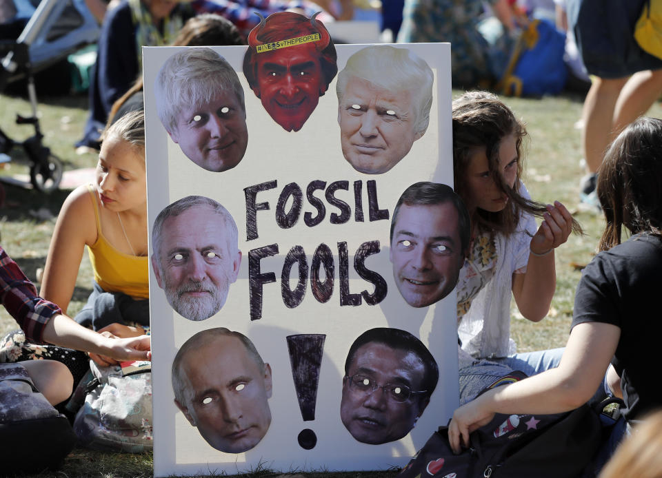 Climate protesters hold a banner bearing the images of world leaders as they demonstrate in London, Friday, Sept. 20, 2019. (Photo: Frank Augstein/AP)