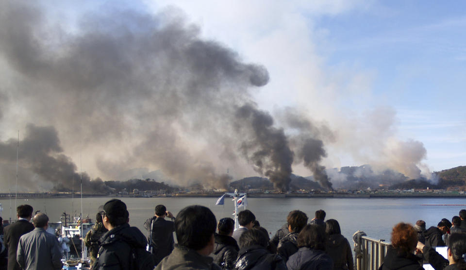 FILE - South Korean villagers watch smoke rising from South Korea's Yeonpyeong island near the border against North Korea on Nov. 23, 2010. North Korea’s recent escalation of threats and endless tests of weapons aimed toward South Korea haven't done much to upset the calm in Seoul. Residents in the South's capital feel they've seen it all before and it's North Korea's way of getting attention in an election year for South Korea and the U.S. (AP Photo/Yonhap, File)