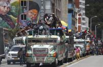 Members of the Indigenous Guard arrive in a caravan of buses to take part in a national strike in Bogota, Colombia, Wednesday, Oct. 21, 2020. Workers' unions, university students, human rights defenders, and Indigenous communities have gathered for a day of protest in conjunction with a national strike across Colombia. The protest is against the assassinations of social leaders, in defense of the right to protest and to demand advances in health, income and employment. (AP Photo/Fernando Vergara)