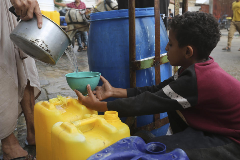 A Palestinian fills a cup with drinking water during the ongoing Israeli bombardment of the Gaza Strip in Rafah on Saturday, Oct. 28, 2023. (AP Photo/Hatem Ali)