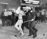 FILE - In this Aug. 28, 1968, file photo, a demonstrator with his hands on his head is led by Chicago Police down Michigan Avenue during a confrontation with police and National Guardsmen who battled demonstrators near the Conrad Hilton Hotel, headquarters for the Democratic National Convention. During the convention, hundreds of demonstrators waged war with police and National Guardsmen on the streets of Chicago. (AP Photo/File)