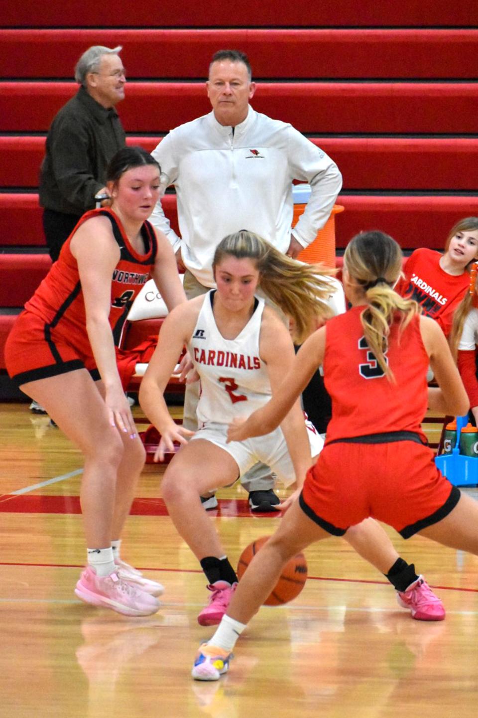 Coldwater's Rylie Van Aken splits a Northwest double team as head coach Ken Smoker and the managers look on Tuesday night.