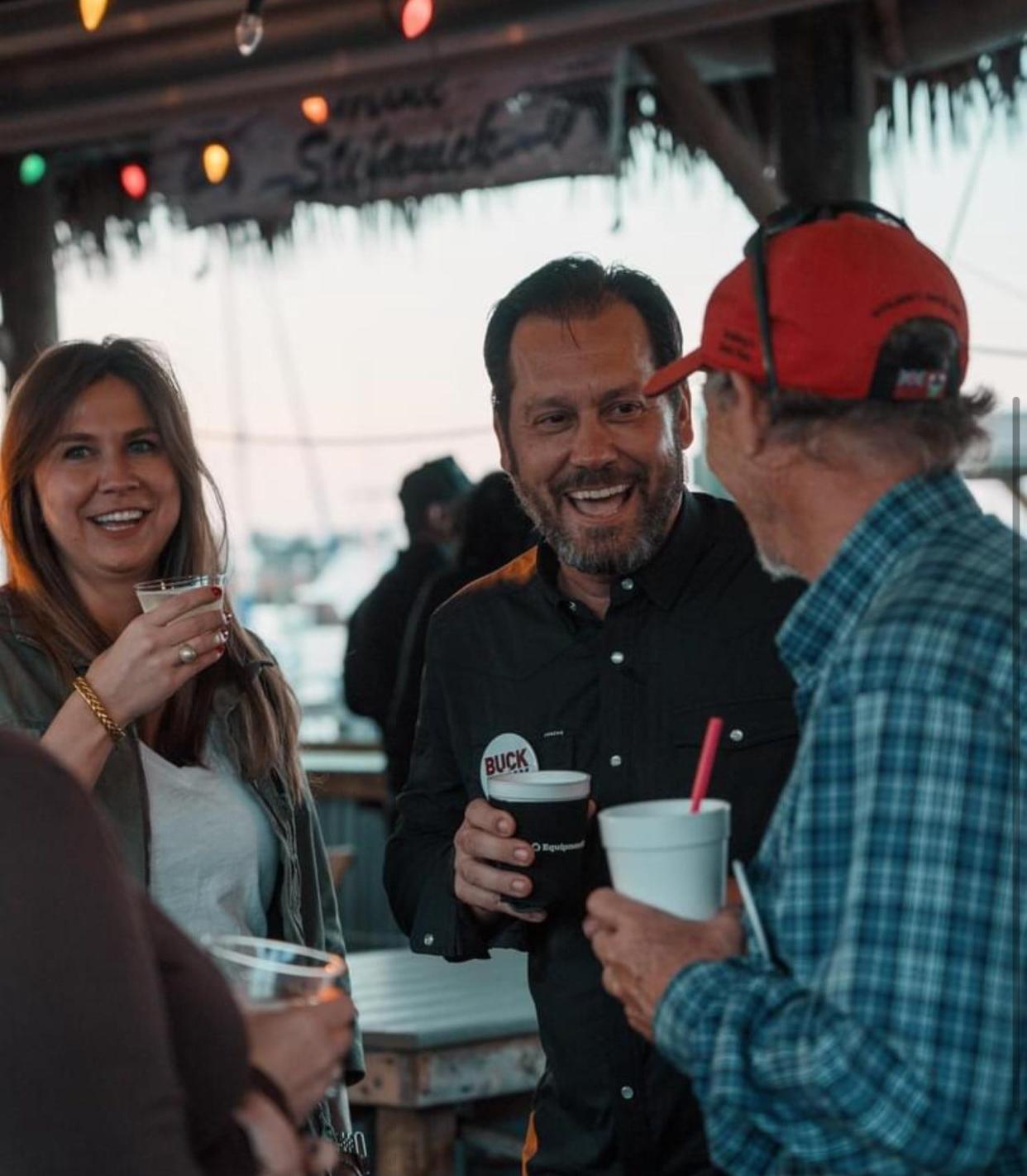 Buck Holly shares a laugh with friends during a campaign event at Fish Tales in Richmond Hill.