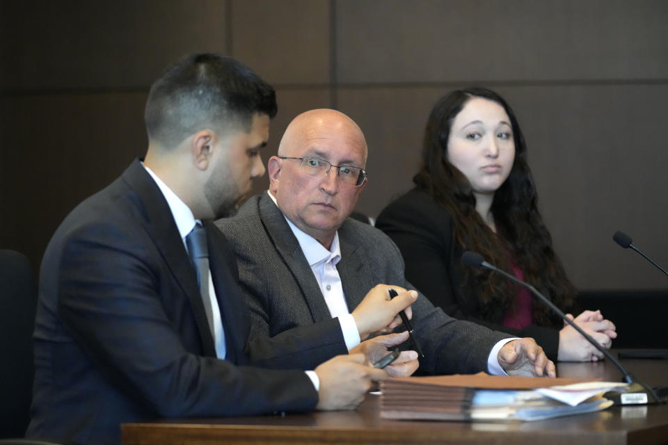 Robert E. Crimo Jr., center, receives a pen from his attorney George Gomez, left, as attorney Alanna Myerson looks on during an appearance before Judge George D. Strickland at the Lake County Courthouse, Friday, July 14, 2023, in Waukegan, Ill. Judge George Strickland on Friday set a Nov. 6 trial date for Crimo Jr. who is charged with helping his son obtain a gun license three years before the son allegedly shot dead seven people at a Fourth of July parade in suburban Chicago last year. (AP Photo/Nam Y. Huh, Pool)