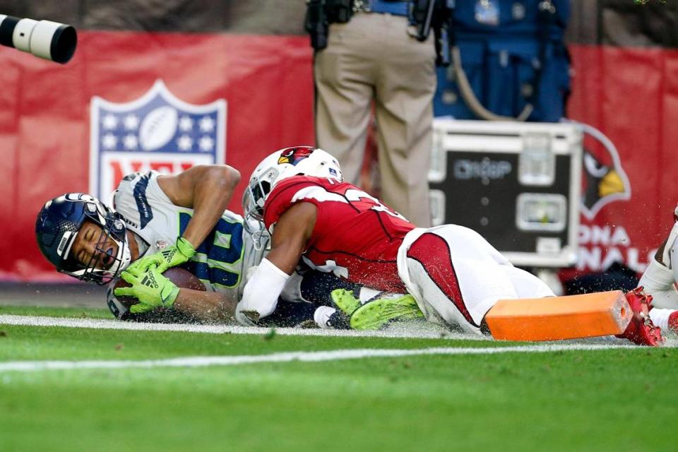 Seattle Seahawks wide receiver Tyler Lockett, left, scores a touchdown as Arizona Cardinals free safety Jalen Thompson, right, makes a late tackle during the first half of an NFL football game Sunday, Jan. 9, 2022, in Glendale, Ariz. (AP Photo/Ralph Freso)