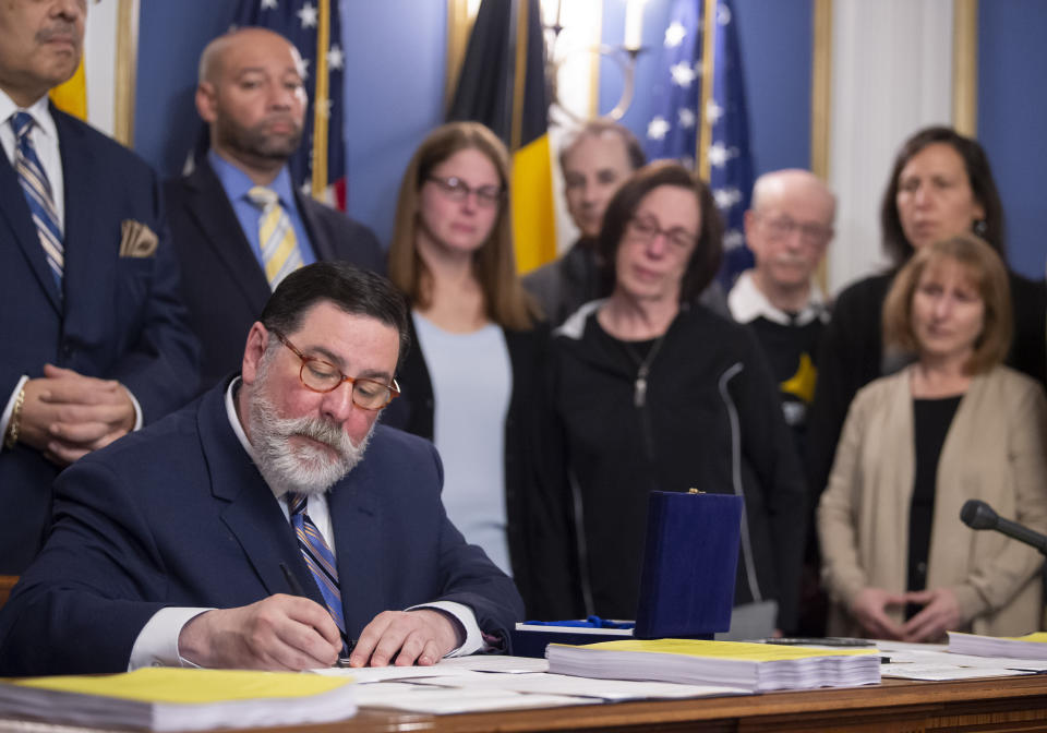Pittsburgh Mayor Bill Peduto, surrounded by supporters and family members of Tree of Life synagogue shooting victims, signs three gun-control bills into law, Tuesday, April 9, 2019, at the City-County Building in downtown Pittsburgh. (Steph Chambers/Pittsburgh Post-Gazette via AP)