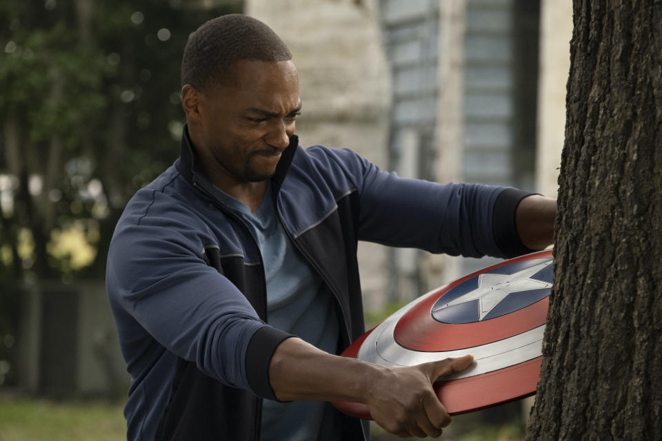The Falcon (Anthony Mackie) pulls Captain America's shield from a tree in a scene from the TV series The Falcon and the Winter Soldier