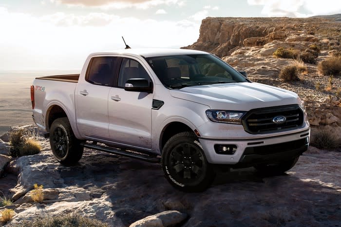 A white Ford Ranger perched on a rock