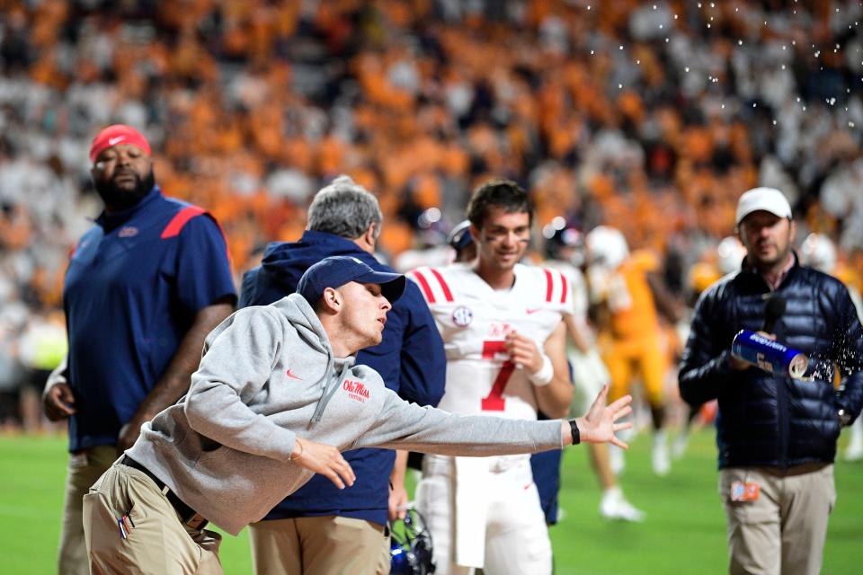 An Ole Miss coach tries to catch a can of beer as it is thrown onto the sidelines during an SEC football game between Tennessee and Ole Miss at Neyland Stadium in Knoxville, Tenn. on Saturday, Oct. 16, 2021. Tennessee fans threw debris onto the field in objection to a ruling on a play in the end of the fourth quarter.