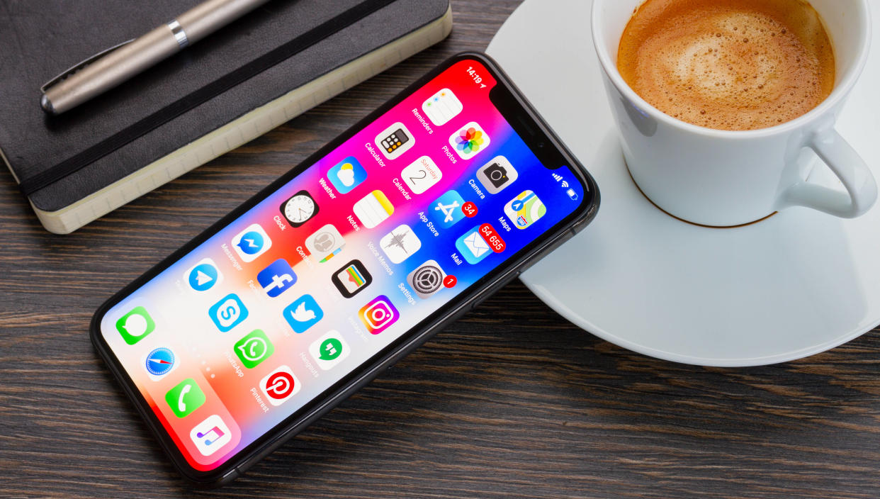  iPhone X on a desk next to a coffee 