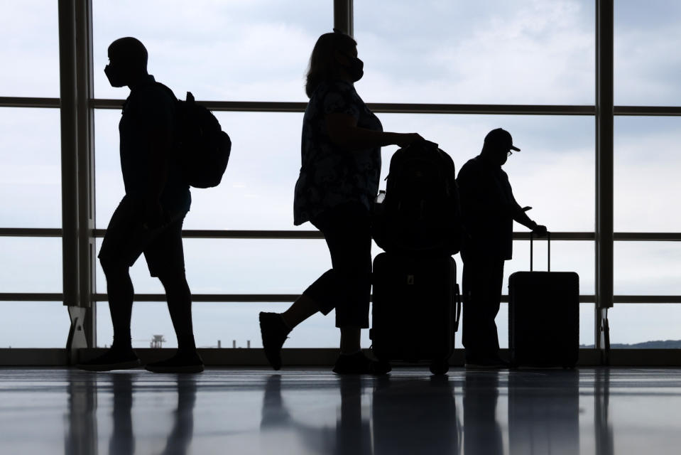 ARLINGTON, VA - MAY 28: Travelers pass through the concourse at Ronald Reagan Washington National Airport on the eve of Memorial Day long weekend May 28, 2021 in Arlington, Virginia. As COVID-19 related restrictions are loosen up across the country, more than 37 million Americans are expected to travel, either by driving, flying or catching a train, over the Memorial Day weekend this year, according to AAA. (Photo by Alex Wong/Getty Images)