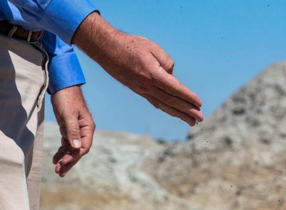 County Supervisor Ryan Kelley releases from his hand an example of the fine clay particulate found in Calipatria.