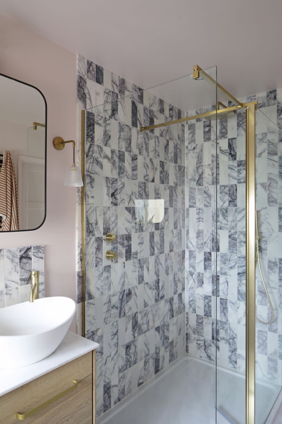 a marble tiled shower area in a neutral calm bathroom