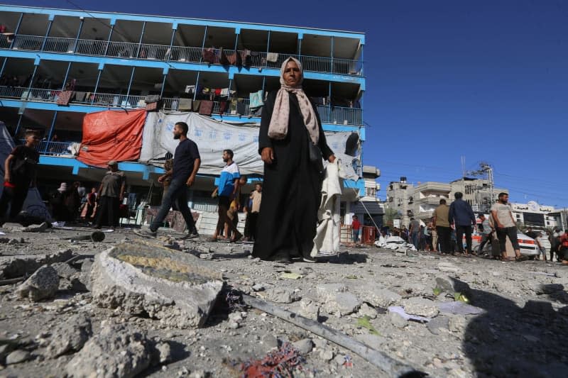 Palestinians stand in the courtyard of a school after an Israeli attack at the school of United Nations Relief and Works Agency for Palestine Refugees in the Near East (UNRWA) at Nuseirat Refugee Camp. Omar Ashtawy/APA Images via ZUMA Press Wire/dpa