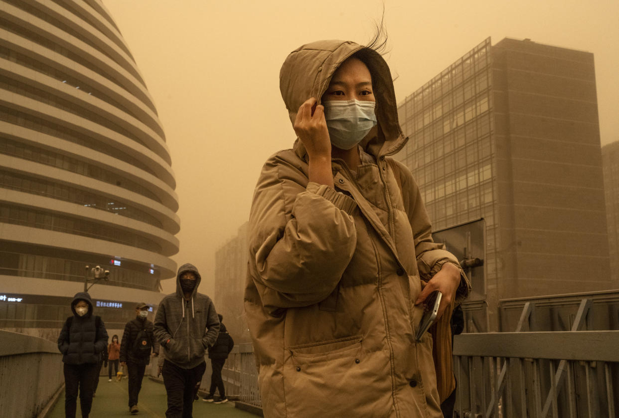 A woman commutes during a sandstorm on March 15, 2021 in Beijing. (Kevin Frayer / Getty Images)
