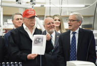 President Donald Trump holds a photograph of coronavirus as Dr. Steve Monroe,right, with CDC speaks to members of the press at the headquarters of the Centers for Disease Control and Prevention in Atlanta on Friday, March 6, 2020. President Trump's trip to the Centers for Disease Control and Prevention, briefly scuttled Friday because of unfounded fears that someone there had contracted the coronavirus, was back on, giving the president another chance to calm growing alarm about the spread of the virus in America. (Hyosub Shin/Atlanta Journal-Constitution via AP)