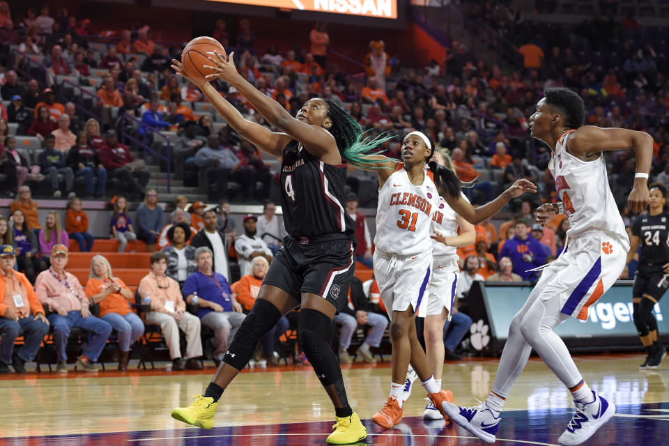 South Carolina's Aliyah Boston (4) grabs the ball while defended by Clemson's Shania Meertens (31) and Kobi Thorton during the first half of an NCAA college basketball game Sunday, Nov. 24, 2019, in Clemson, S.C. (AP Photo/Richard Shiro)