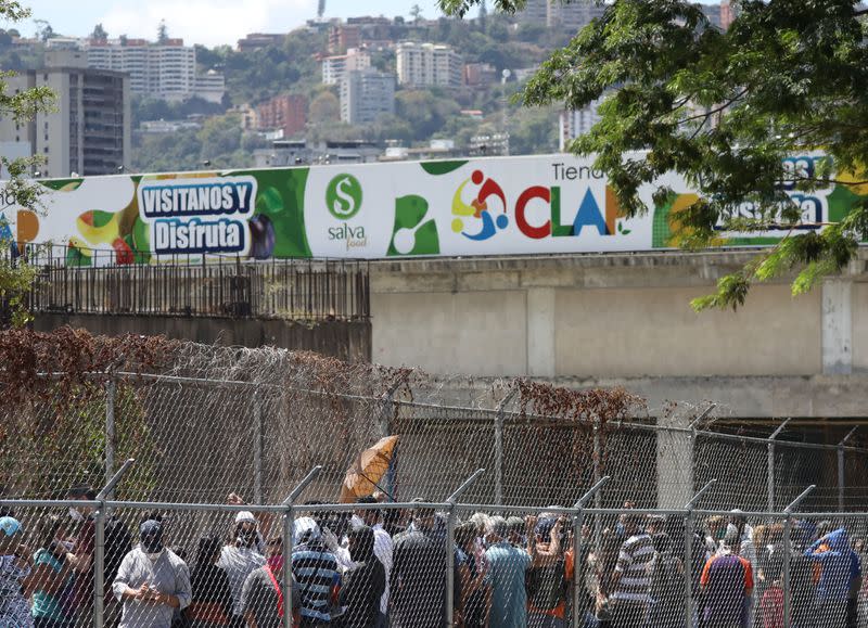 People queue in front of a supermarket during the national quarantine in response to the spreading coronavirus disease (COVID-19) in Caracas