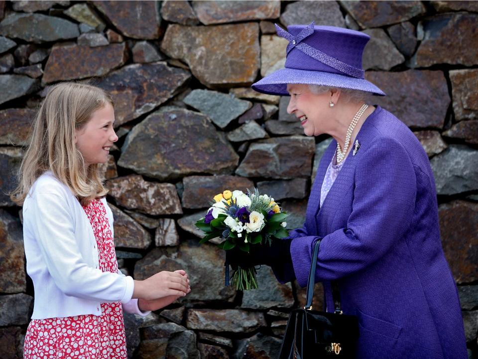 Queen Elizabeth receives flowers from a child in 2009.