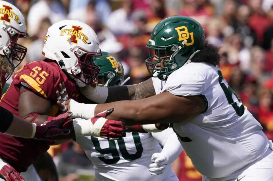 Baylor defensive tackle Siaki Ika, right, charges at Iowa State offensive lineman Darrell Simmons Jr. (55) during the first half of an NCAA football game, Saturday, Sept. 24, 2022, in Ames, Iowa.