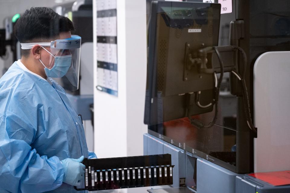 Jeniffer Gutierrez runs COVID-19 tests in the lab on Jan. 11, 2022, at Sonora Quest Laboratories in Phoenix.