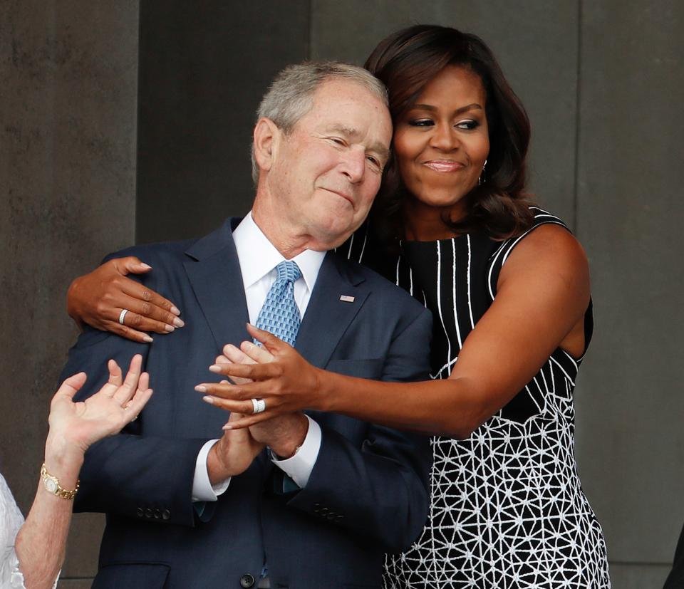 First lady Michelle Obama hugs former President George W. Bush during the dedication ceremony for the Smithsonian Museum of African American History and Culture on the National Mall in Washington on Sept. 24, 2016.