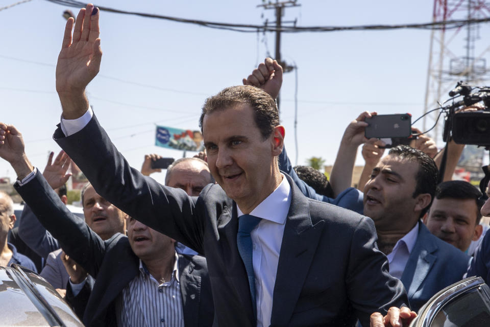 FILE - In this May 26, 2021, file photo, Syrian President Bashar Assad, center, waves to his supporters at a polling station during the Presidential elections in the town of Douma, in the eastern Ghouta region, near Damascus, Syria. The United Arab Emirates’ crown prince received a rare telephone call from Syrian President Assad in which they discussed strengthening relations and cooperation, Syria’s state media reported Wednesday, Oct. 20. The call between Assad and UAE’s Crown Prince Mohammed bin Zayed came as some Arab countries are improving relations with Syria, a decade after the country’s civil war began. (AP Photo/Hassan Ammar, File)