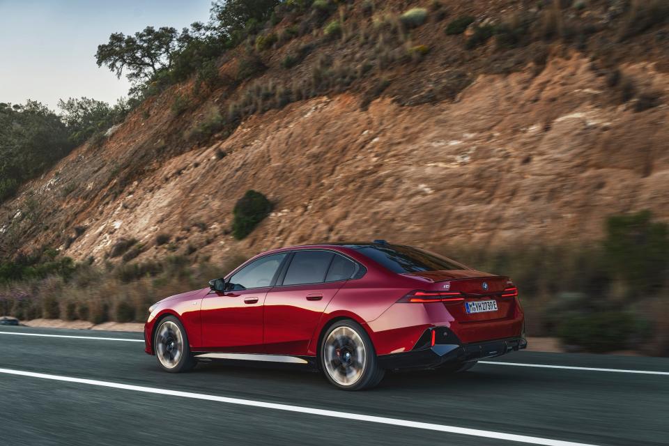 A red BMW sedan driving down a highway