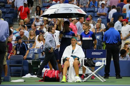 Sep 9, 2015; New York, NY, USA; Victoria Azarenka of Belarus sits under an umbrella as rain begins to fall during the match against Simona Halep of Romania on day ten of the 2015 U.S. Open tennis tournament at USTA Billie Jean King National Tennis Center. Anthony Gruppuso-USA TODAY Sports / Reuters