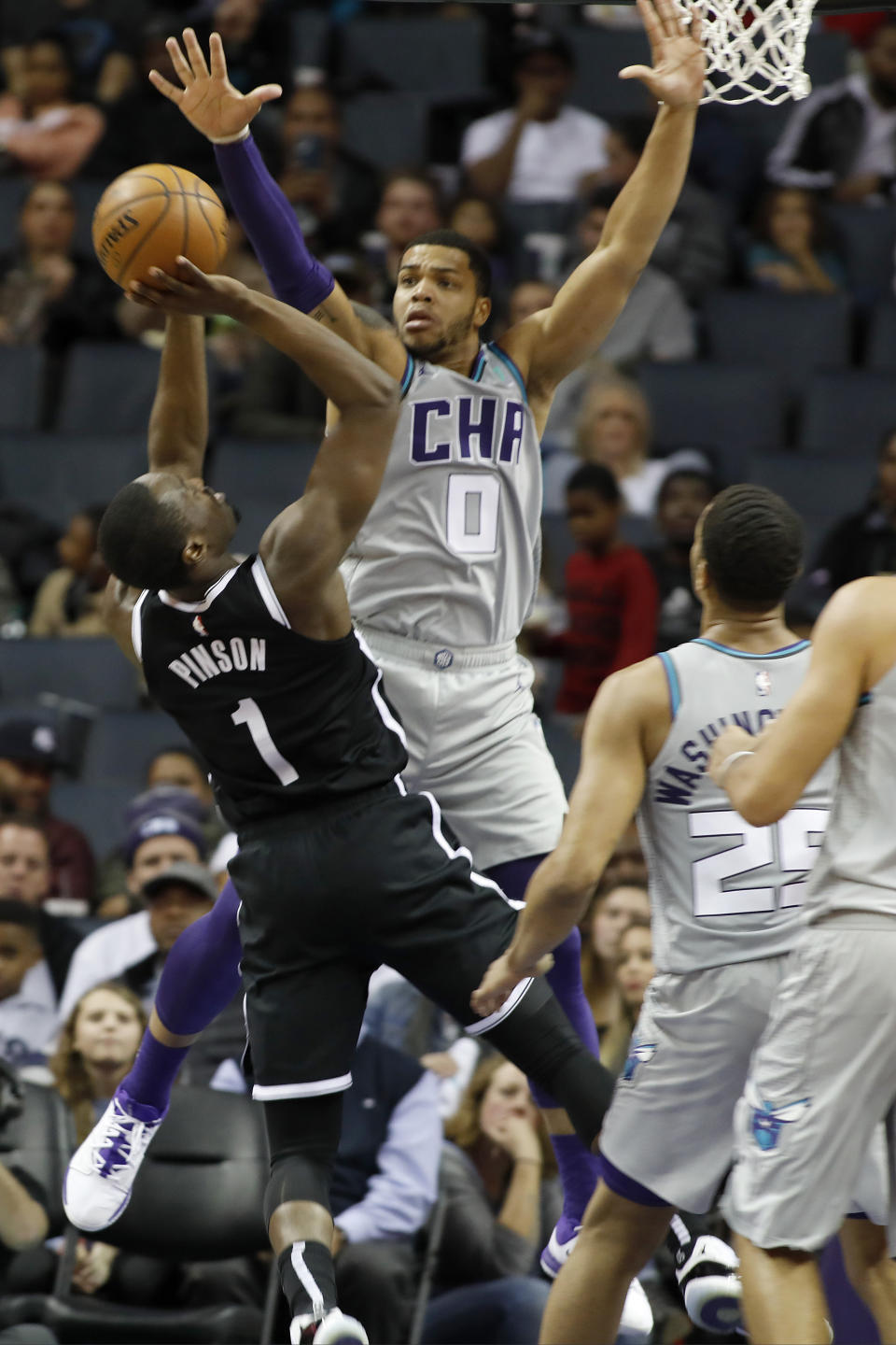 Brooklyn Nets' Theo Pinson (1) tries to get a shot off over Charlotte Hornets' Miles Bridges (0) during the second half of an NBA basketball game in Charlotte, N.C., Friday, Dec. 6, 2019. The Nets won 111-104. (AP Photo/Bob Leverone)