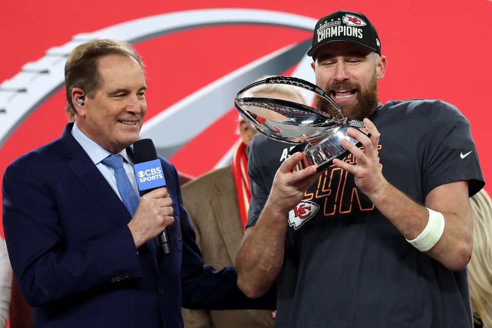 Travis Kelce #87 of the Kansas City Chiefs celebrates with the Lamar Hunt Trophy as Jim Nantz looks on after a 17-10 victory against the Baltimore Ravens in the AFC Championship Game at M&T Bank Stadium on January 28, 2024 in Baltimore, Maryland.