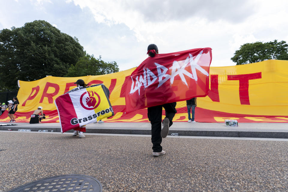 Women dance in front of a sign covering the gate outside the White House during a rally in support of imprisoned Native American activist Leonard Peltier, Tuesday, Sept. 12, 2023, in Washington. (AP Photo/Stephanie Scarbrough)