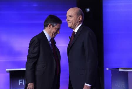 French politicians Alain Juppe (R) and Francois Fillon are seen on stage as they attend the third prime-time televised debate as they campaign in the second round for the French center-right presidential primary election in Paris, France, November 24, 2016. REUTERS/Eric Feferberg/Pool