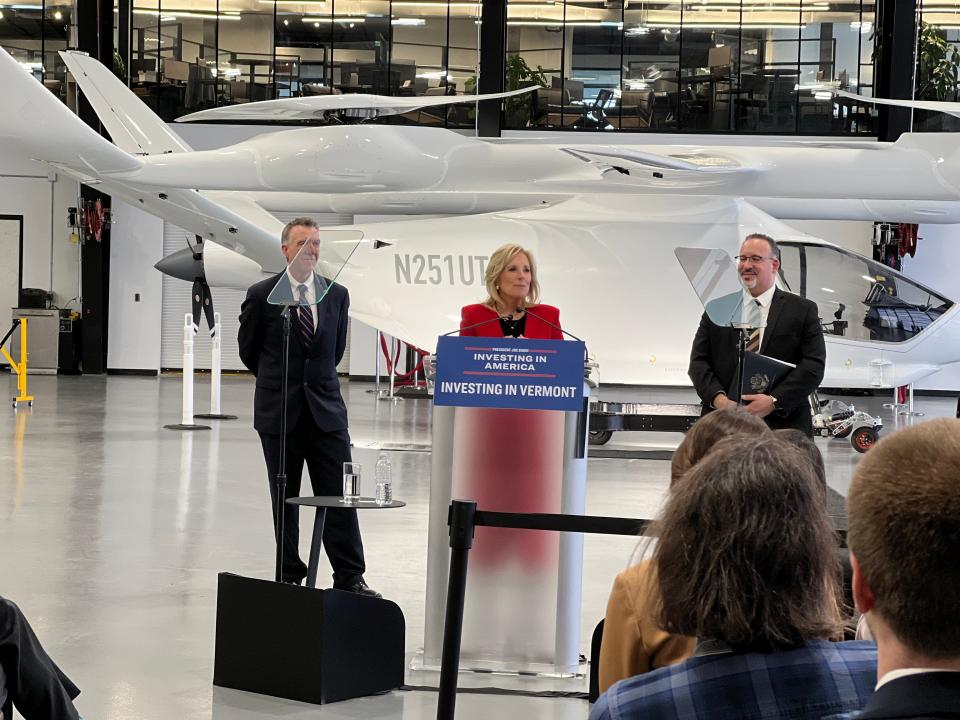 First Lady Jill Biden addresses the audience inside the BETA Technologies hangar in front of an electric aircraft positioned in the background at Patrick Leahy Burlington International Airport on April 5, 2023. She is joined by U.S. Secretary of Education Miguel Cardona, right, to talk about career-focused education and President Biden's Investing in America agenda. Vermont Governor Phil Scott is pictured right.