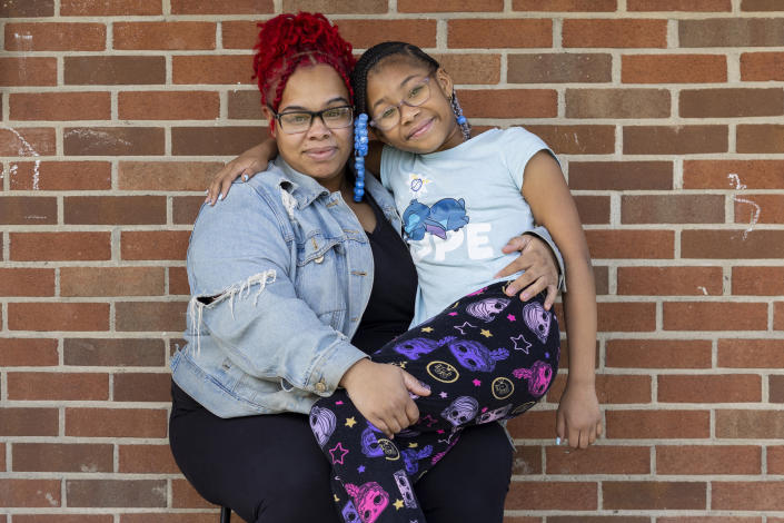 Ashley Martin and her daughter, Ke'Arrah Jessie, 9, pose for a portrait outside of their apartment in Niagara Falls, N.Y., on Monday, April 3, 2023. (AP Photo/Lauren Petracca)