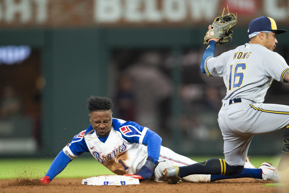 Milwaukee Brewers second baseman Kolten Wong (16) tags out Atlanta Braves' Ozzie Albies (1) in the sixth inning of a baseball game Saturday, May 7, 2022, in Atlanta. (AP Photo/Hakim Wright Sr)