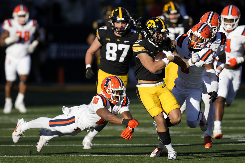 Iowa wide receiver Kaleb Brown (3) runs from Illinois defensive back Miles Scott (10) and defensive back Zachary Tobe (5) after catching a pass during the first half of an NCAA college football game, Saturday, Nov. 18, 2023, in Iowa City, Iowa. (AP Photo/Charlie Neibergall)