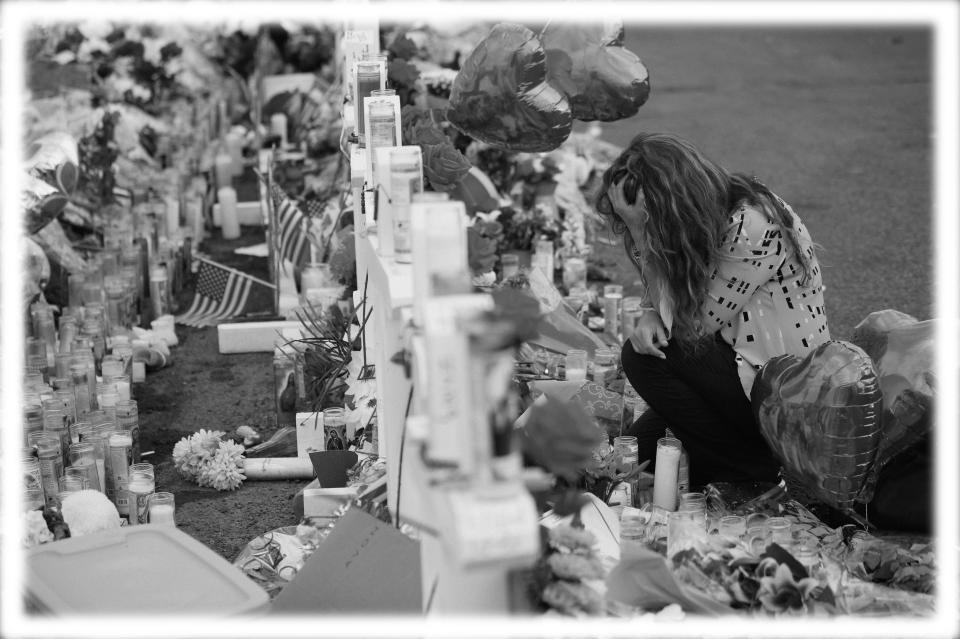 Gloria Garces kneels in front of crosses at a makeshift memorial near the scene of a mass shooting at a shopping complex Tuesday, Aug. 6, 2019, in El Paso, Texas. (Photo: John Locher/AP; digitally enhanced by Yahoo News)