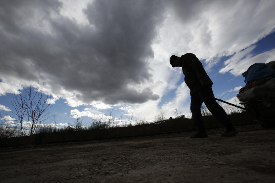 Bosnian man Dzevad Hrustic drags a load found in the garbage close to the coal mine in Bosnian town of Tuzla, 140 kms north of Sarajevo on Wednesday, Feb. 12, 2014. The violence engulfing Bosnia in recent days, with scenes of burning government buildings and protesters pelting police with stones, has many root causes. One of them is the failed privatizations of state-owned companies. (AP Photo/Amel Emric)