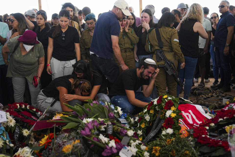 Mourners attend the funeral of the Kotz family in Gan Yavne, Israel, Tuesday, Oct. 17, 2023. The Israeli family of five was killed by Hamas militants on Oct. 7 at their house in Kibbutz Kfar Azza near the border with the Gaza Strip, More than 1,400 people were killed and some 200 captured in an unprecedented, multi-front attack by the militant group that rules Gaza. (AP Photo/Ohad Zwigenber)