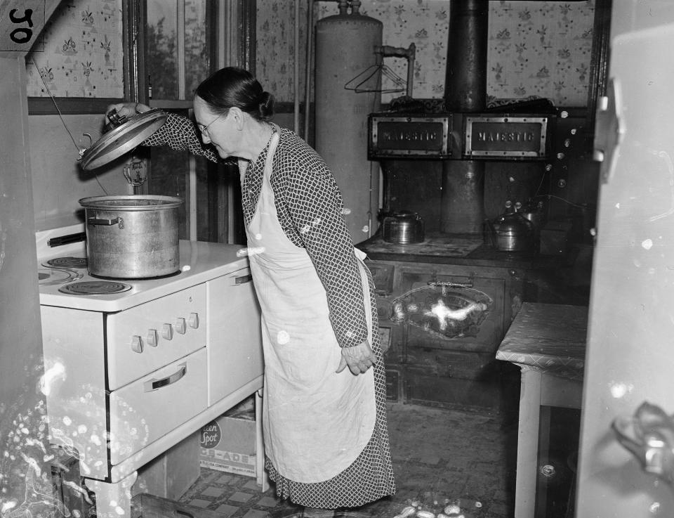 FILE - In this April 1938, file photo, Mrs. G.S. Davis, wife of a Corinth, Miss., farmer, works in her electrified kitchen in their farm home somewhere in Tenn. The wood burning stove hasn't yet been removed. Mr. Davis has numerous electrical conveniences installed in the farm, among them a potato drier, electric pump, electric charged fence constructed around the yard. California's energy policy and planning agency wants to transition new homes away from gas-powered appliances. The California Energy Commission released a draft building standards code on Thursday, May 6, 2021, that would require new homes to be equipped with circuits and panels that support all-electric appliances for heating, cooking and drying clothes. (AP Photo/Horace Cort, File)