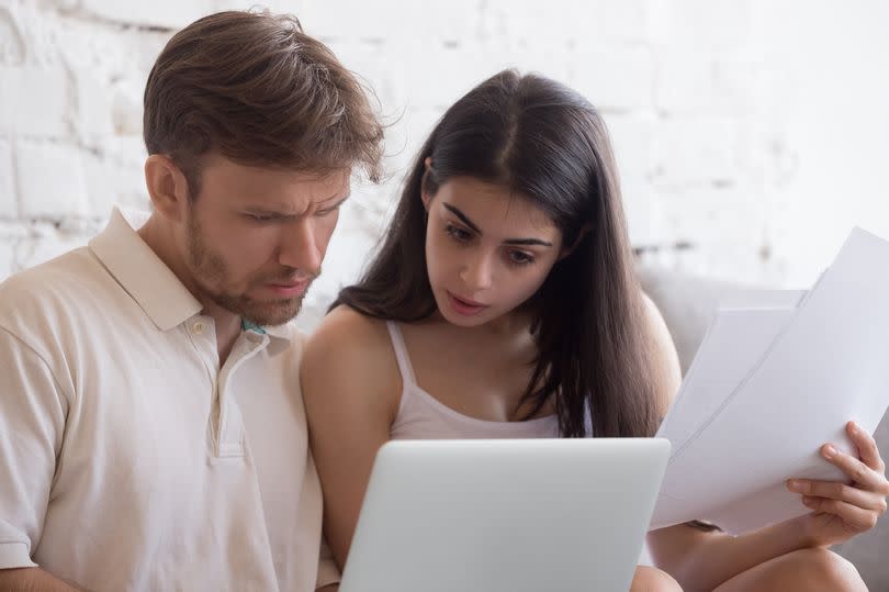 A young couple check their bills