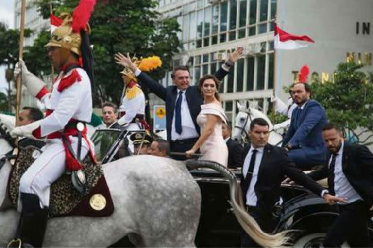 Bolsonaro, junto a su mujer, Michelle, saluda desde el Rolls Royce