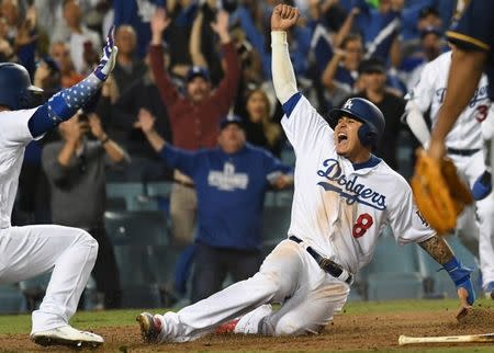 FILE PHOTO: Oct 16, 2018; Los Angeles, CA, USA; Los Angeles Dodgers shortstop Manny Machado (8) celebrates with catcher Yasmani Grandal (9) after scoring on an RBI single by center fielder Cody Bellinger (not pictured) defeat the Milwaukee Brewers in the thirteenth inning in game four of the 2018 NLCS playoff baseball series at Dodger Stadium. Mandatory Credit: Richard Mackson-USA TODAY Sports