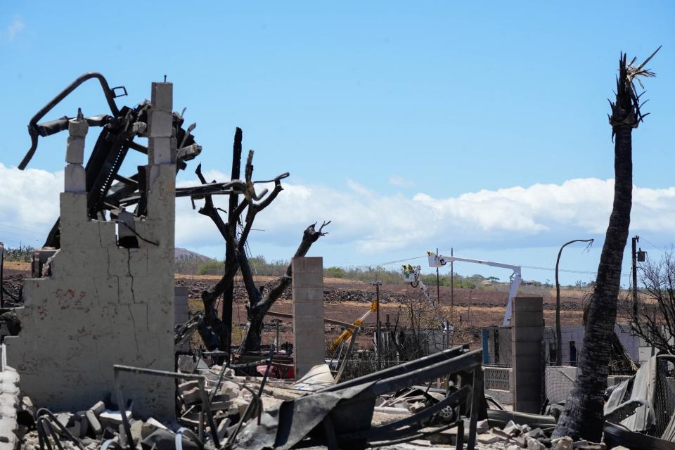 Hawaiian Electric works on power lines in Lahaina, Hawaii, on Aug. 18. At least 114 people died in the Aug. 8 fire, making it the deadliest U.S. wildfire of the past century. A lawsuit filed on behalf of five Lahaina residents alledges the local power company, Hawaiian Electric, played a substantial role in the fires.