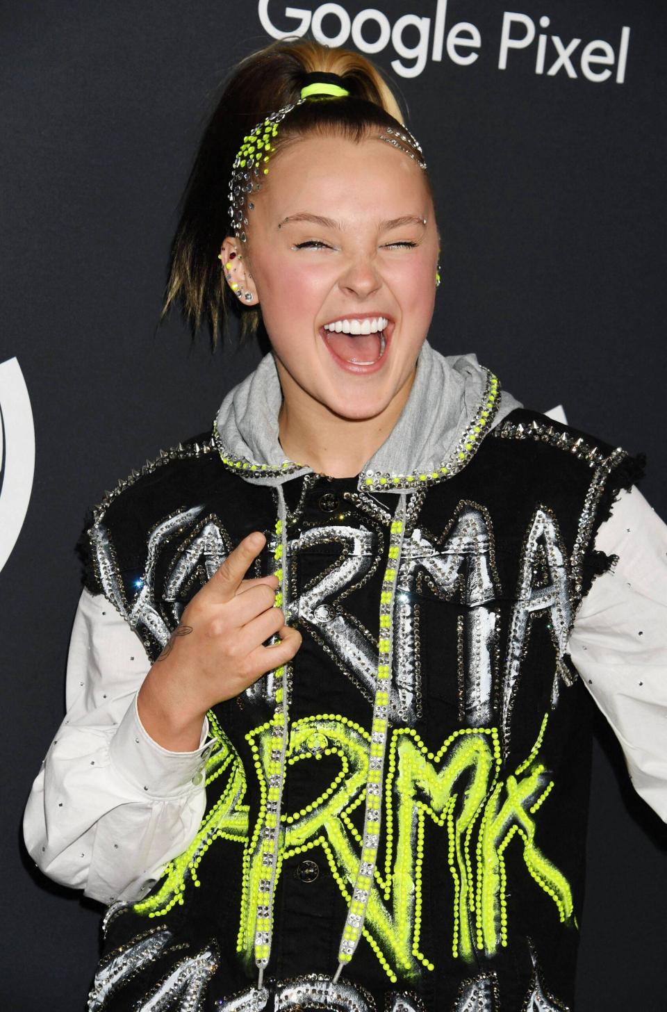 JoJo Siwa wears a black and grey hoodie