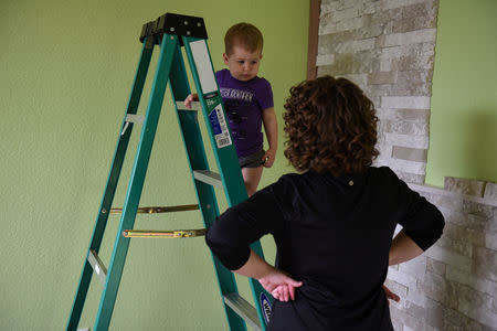 Lauren Hoffmann, 29, a college program manager, looks at her two-year old son Asa as he climbs a ladder in the nursery they are decorating for Micah in San Antonio, Texas, U.S., February 7, 2019. REUTERS/Callaghan O'Hare